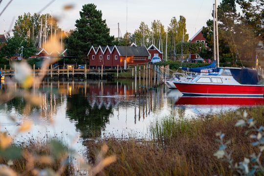 Billede fra havnen med små røde træhuse i baggrunden