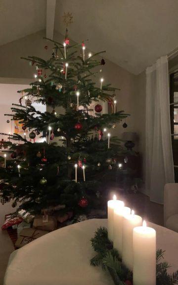Et stort juletræ med stearinlys i stuen