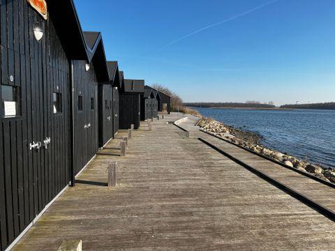 Promenaden langs vandet og de sorte træhuse 