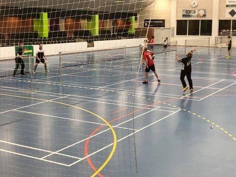 Et hold spiller badminton i hallen