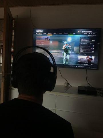 Ung mand, der sidder og gamer