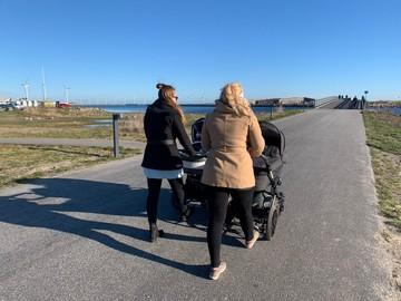 Väninnor på promenad med barnvagnar