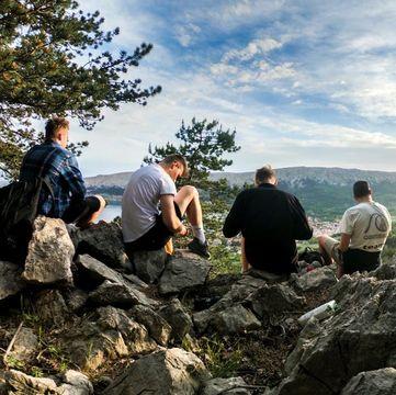 Drengegruppe, der sidder på en klippe