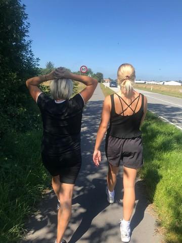 To kvinder er ude at motionere langs cykelstien i et flot sommervejr med blå himmel, efter de har mødt hinanden på Boblberg