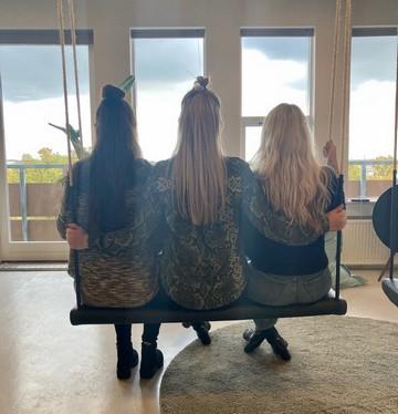 Tre veninder, der har mødt hinanden på Boblberg, sidder sammen på en stor gynge