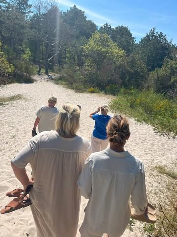 Fire modne kvinder, som er blevet veninder på Boblberg, går tur sammen på stranden