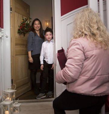 En mor og søn står i døren og tager imod deres julegæst