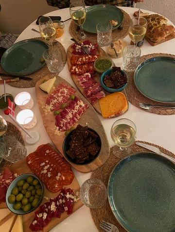 Et flot dækket bord til madklubben med lækker tapas, stearinlys og vin